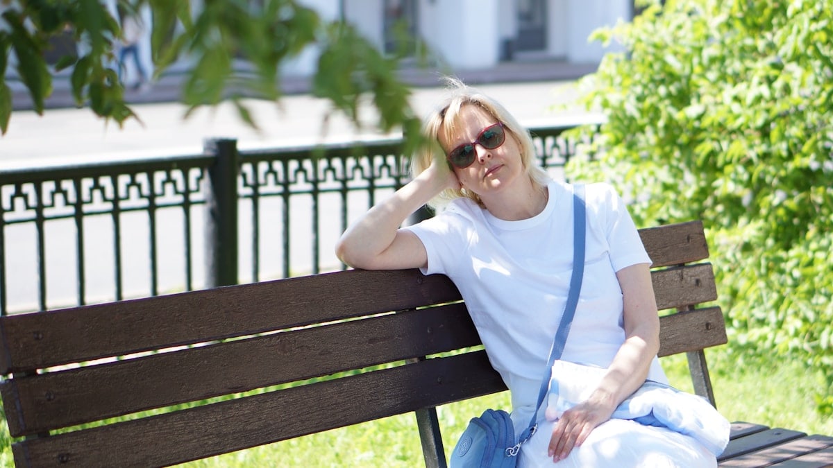 A woman sitting on a bench in a park
