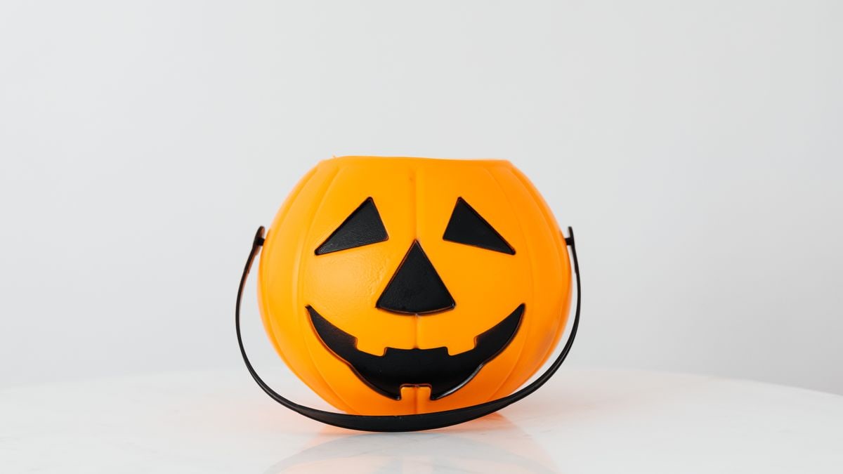 Bright orange pumpkin bucket for Halloween, perfect for trick-or-treat candy collection.